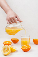 Hand pouring orange juice in glass