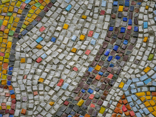 A fragment of an abstract mosaic ceramic panels on the wall. Multicolored stones.
