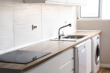 White modern kitchen with white furnitures and wooden floor