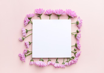 Beautiful fresh flowers and blank card on color background