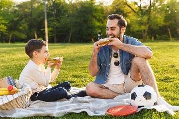 Happy young father having a picnic with his little son