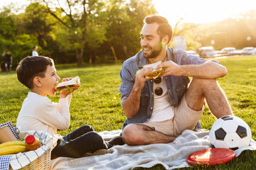 Happy young father having a picnic with his little son