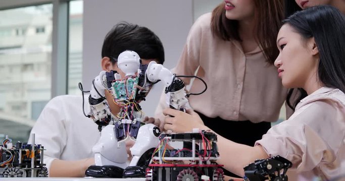 Group of electronics engineer try to fix robot at lab. Technology and innovation concept.