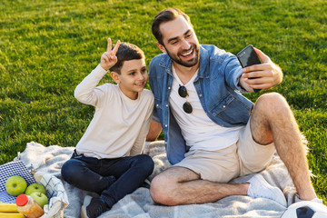 Happy young father having a picnic with his little son