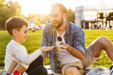 Happy young father having a picnic with his little son