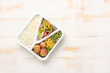 School lunch box with tasty food on white wooden table