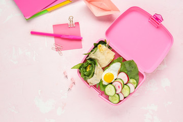 School lunch box with tasty food and stationery on light background