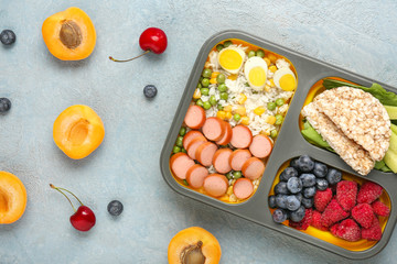 School lunch box with tasty food on color background