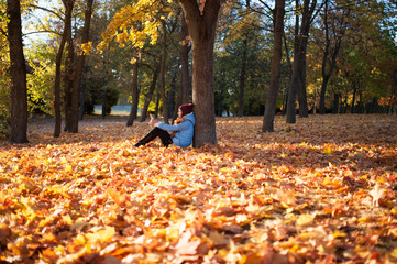 Girl in the autumn forest. Beautiful elegant woman standing in a park in autumn