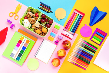 School supplies, colorful stationery, backpack and lunchbox with funny food for kids . Back to school concept lay out