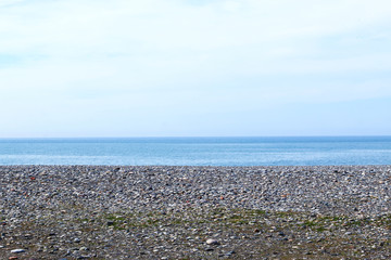 Sea view from pebbles beach. Blue sky and sea. 