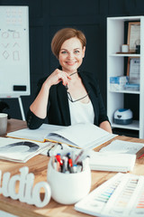 Young businesswoman sitting on the desk in workshop studio