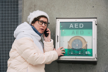 medicine cardiopulmonary resuscitation emergency call. Caucasian woman uses telephone calling 911 help. device box aed automatic defibrillator diseases