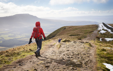 A hiker walking down from the summit of Whernside, part of the Three Peaks in the Yorkshire Dales,...