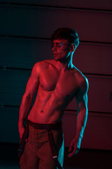 sexy shirtless fireman in protective goggles in darkness
