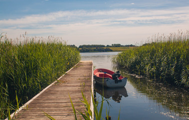 boat on the lake near the jetty in the summer time