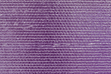 Ribbed texture of purple reflective shiny wall. Shining pink convex foil background. Abstract glitter pattern. Reflective violet surface. Brilliant uneven texture with metallic gloss. Red glossy wall