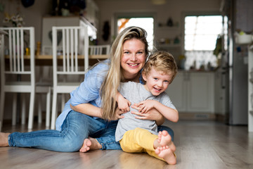 A happy mother with a toddler son indoors at home. Copy space.