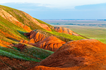 Big Bogdo mountain. Red sandstone outcrops on the slopes sacred mountain in Caspian steppe Bogdo -...