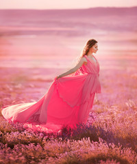 beautiful young girl walks in a field of lavender