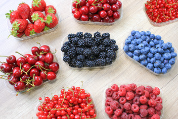 Mix of fresh berries on wooden background, strawberry, blueberry, raspberry,  blackberry, cherry and red currant