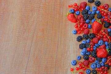 Fototapeta na wymiar Mix of fresh berries on wooden background, strawberry, blueberry, raspberry, blackberry and red currant