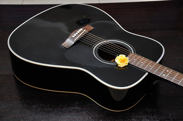 Obraz na płótnie Canvas A yellow rose displayed with a guitar