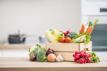 Foto auf Acrylglas Wooden box full of fresh healthy vegetables. Broccoli carrot radish onion garlic corn on wooden kitchen table © weyo
