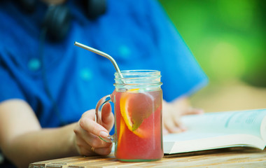 girl in cafe is drinking lemonade using metal reusable straw