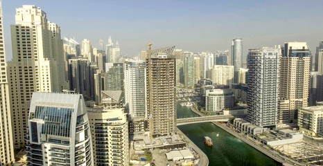 Fototapeta na wymiar DUBAI - DECEMBER 5, 2016: Aerial view of Dubai Marina skyscrapers along artificial canal. Dubai attracts 15 million people annually