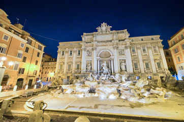 Naklejka premium ROME, ITALY - JUNE 2014: Tourists visit Trevi Fountain at dusk. The city attracts 15 million people annually
