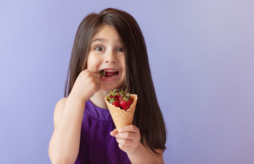 Cute little child girl eting strawberry. Vitamin healthy food. Summer time
