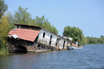 Fototapeta na wymiar View of a canal-street of Vilkovo village (called Ukrainian Venice) with a boat abondoned