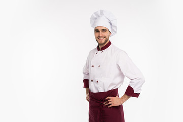 Portrait of positive handsome chef cook in beret and white outfit isolated on white background.