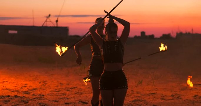 Professional dancers women make a fire show and pyrotechnic performance at the festival with burning sparkling torches.