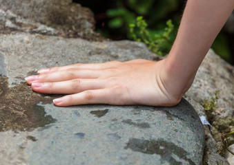 Hand on the stone in the mountains