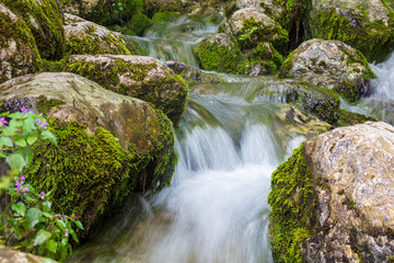 Obraz premium Water runs over rocks in the mountains