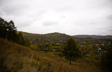 Village on the mountains in the forest of Russia. Autumn in Russia, autumn forest.