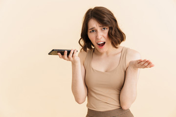 Portrait of uptight caucasian woman 20s dressed in casual clothes screaming while having mobile call on cellphone