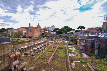 Fototapeta na wymiar ROME, ITALY - JUNE 2014: Tourists visit Imperial Forums. The city attracts 15 million people annually