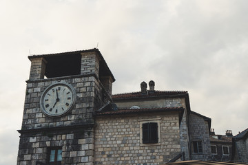 Fototapeta na wymiar Clock Tower in the old town of Kotor, Montenegro. UNESCO World Heritage site Stone pattern building with Clock from the medieval time