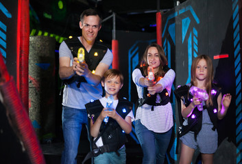 Fototapeta na wymiar Parents and children playing laser tag
