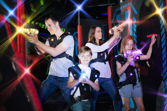Parents and children playing laser tag in beams