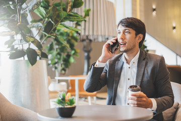 Asian businessman using laptop and mobile phone while working in office