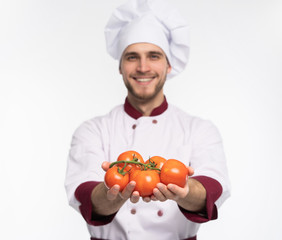 Food service, organic food, healthy diet, cooking and professional culinary concept - chef in white uniform holds vegetables.