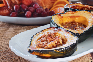 Baked acorn squash with walnuts served for Thanksgiving Day dinner with roast stuffed turkey...