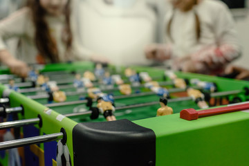 Blurred photo of children having fun and playing table football