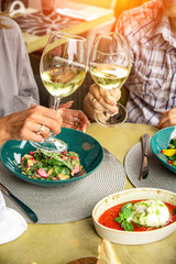 Happy lovers, attractive woman and man enjoy the romance. Attractive couple making selfie, smiling and having fun together. A couple eating salads, drinking wine with taking photos.