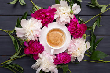 Morning cup of coffee and fresh beautiful pink and white peony flowers on wooden background. Top view. Flat layout