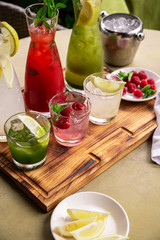 Summer soft drinks, a set of lemonades. Lemonades in jugs on the table, the ingredients of which they are made are arranged around.